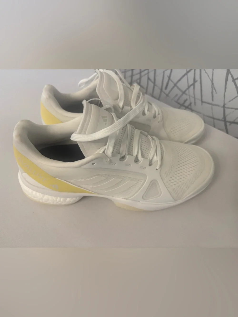 adidas Avaluxe tennis shoes in white with subtle pastel yellow accents. JQ7080